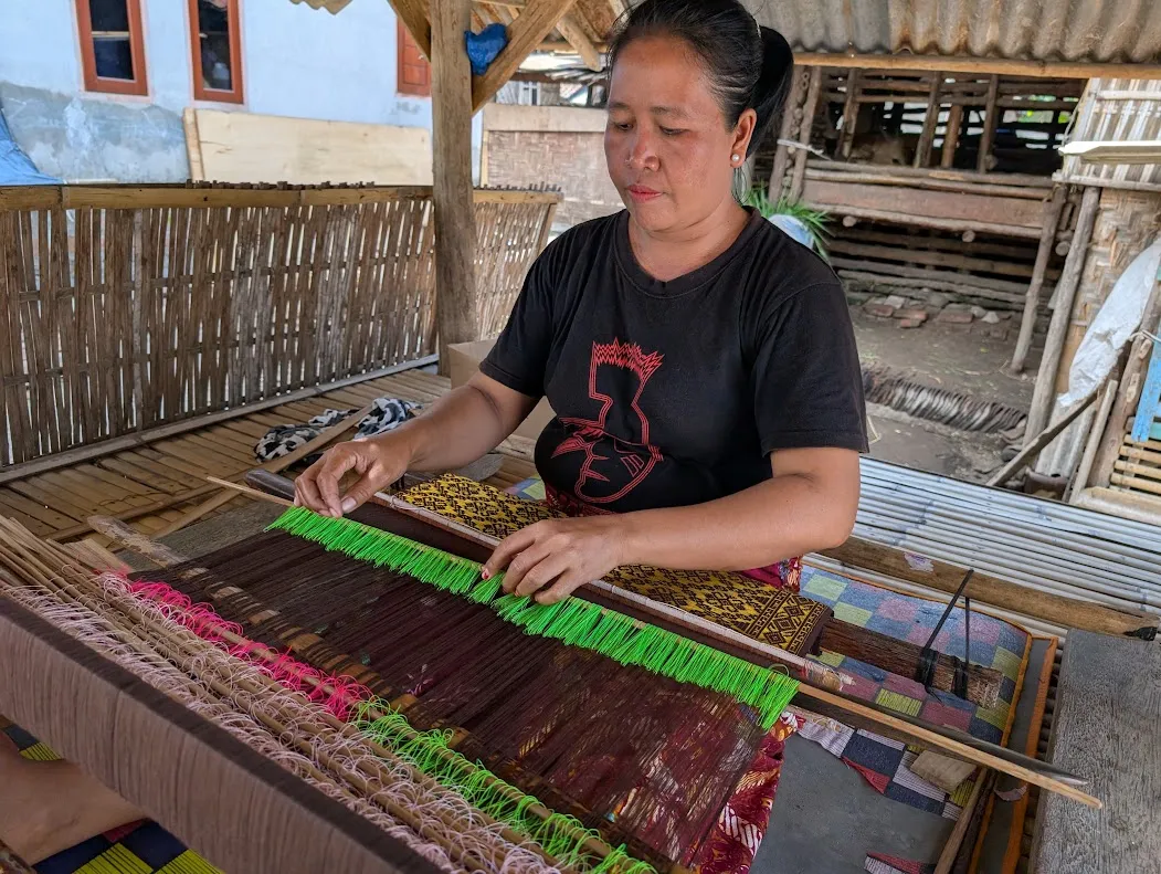 Woman weaving with a traditional loom.