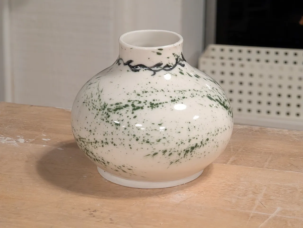 This one was a team-up with Chrissy. I threw the body (porcelain again) and she painted the leaves on with underglaze. I then glazed it (clear) and spattered on some copper oxide.