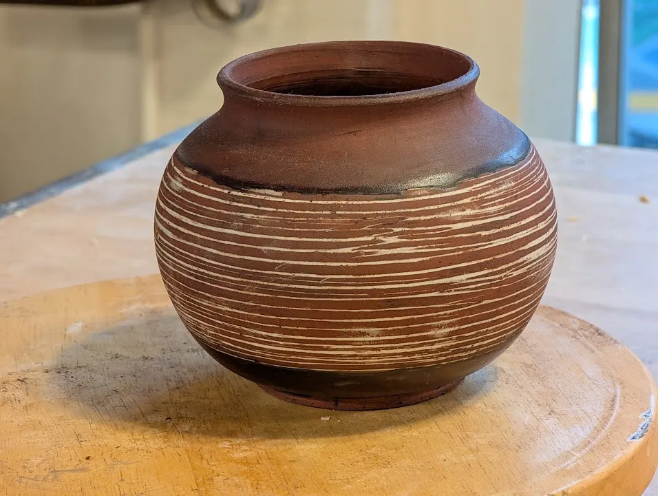 We got back and this pot had just gotten out of the kiln. I am really happy with it. Red velvet clay with a porcelain slip inlay, temoku glaze.